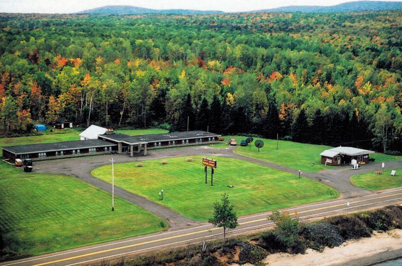 An aerial view of a motel in the middle of a forest