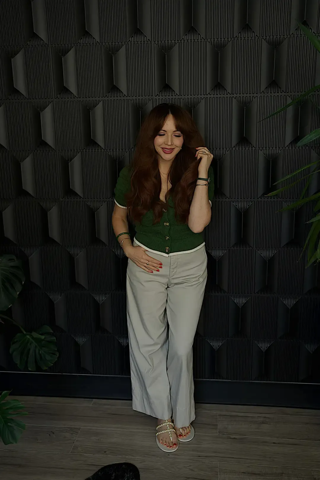 Woman with long polished brunette hair wearing an elevated green outfit
