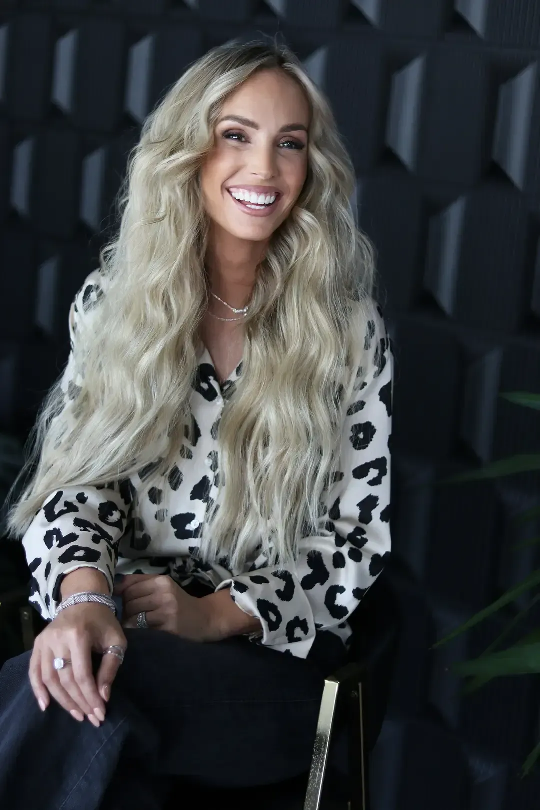 Smiling woman showing her long blonde hair and polished outfit