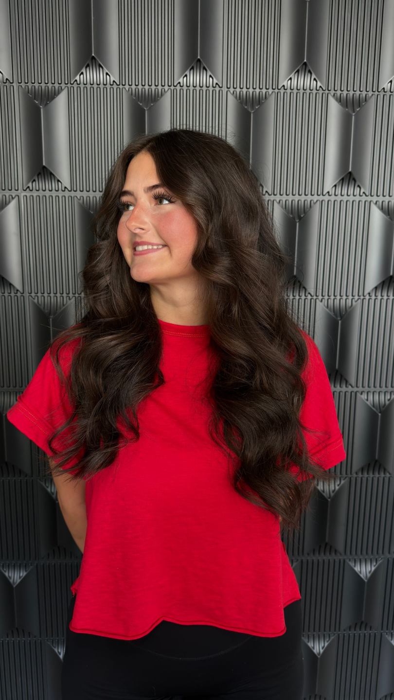 Brunette haircut with face-framing layers and curtain bangs at Glam.Is.On Salon
