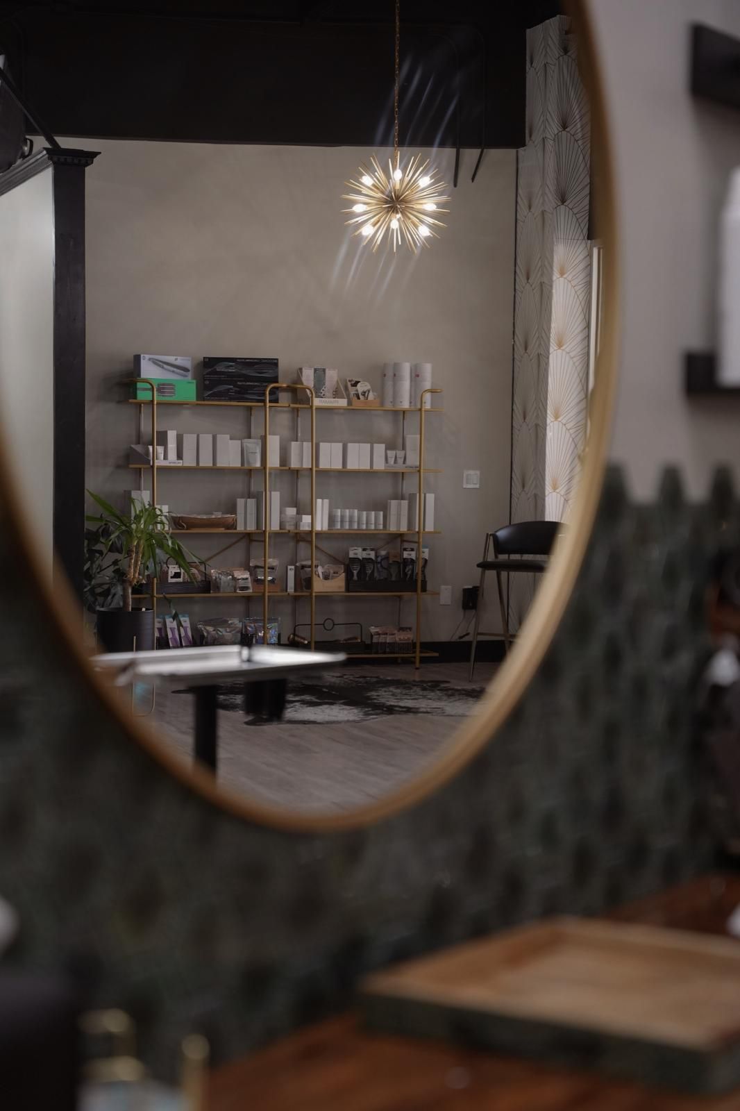 Luxury salon interior with gold chandelier and curated product display at Glam.Is.On