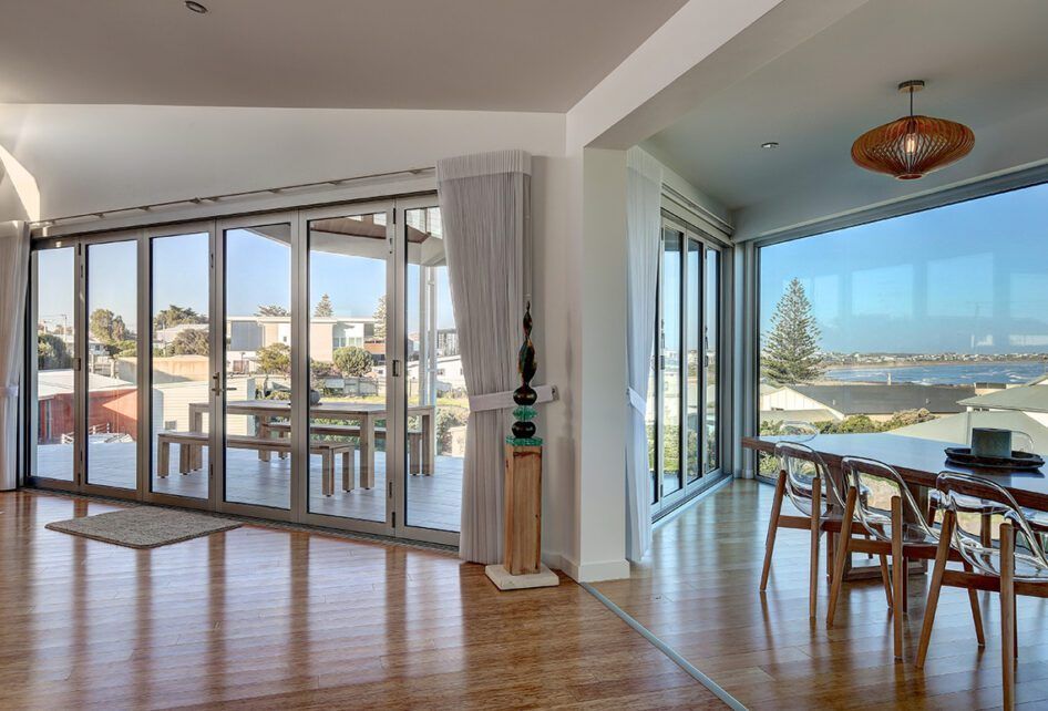 A Living Room with A Table and A Lot of Windows — Distinctive Glass & Aluminium in Port Kembla, NSW