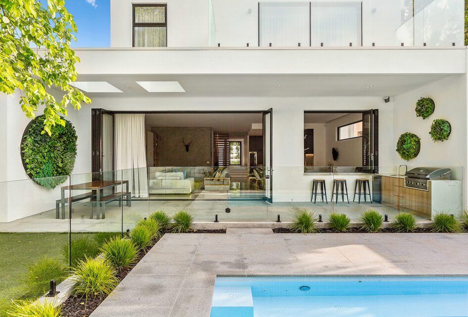 A Large White House with A Swimming Pool in The Backyard — Distinctive Glass & Aluminium in Port Kembla, NSW