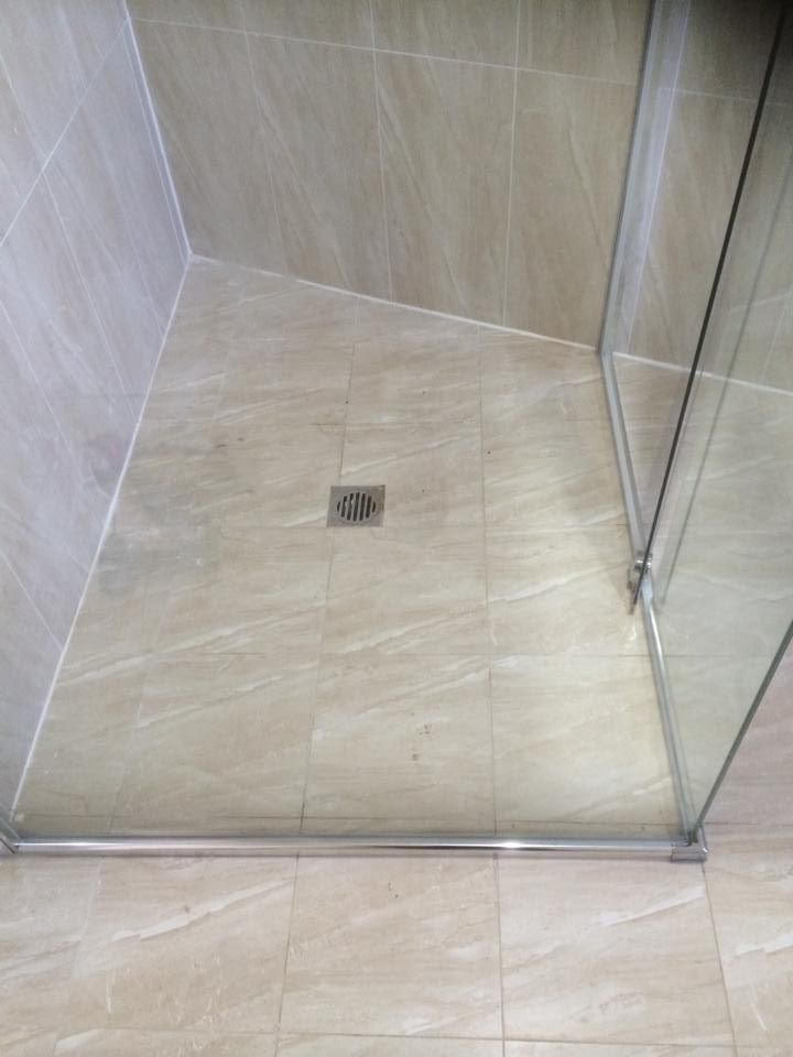 A Bathroom with A Walk in Shower and A Drain on The Floor — Distinctive Glass & Aluminium in Port Kembla, NSW