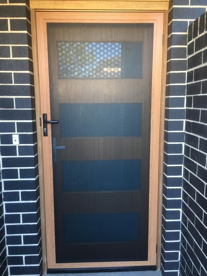 A Screen Door with A Brick Wall Behind It — Distinctive Glass & Aluminium in Port Kembla, NSW