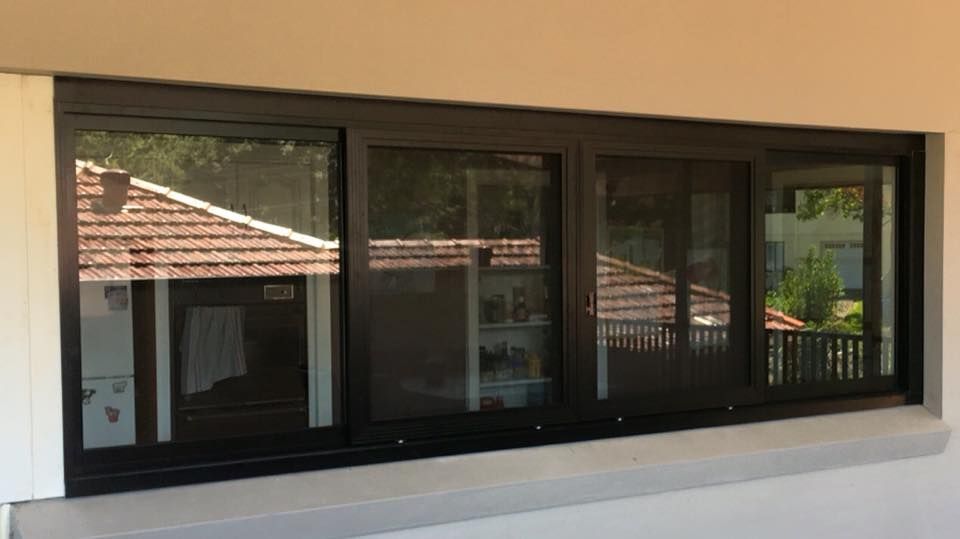 A Large Window on The Side of A Building with A View of A House — Distinctive Glass & Aluminium in Port Kembla, NSW