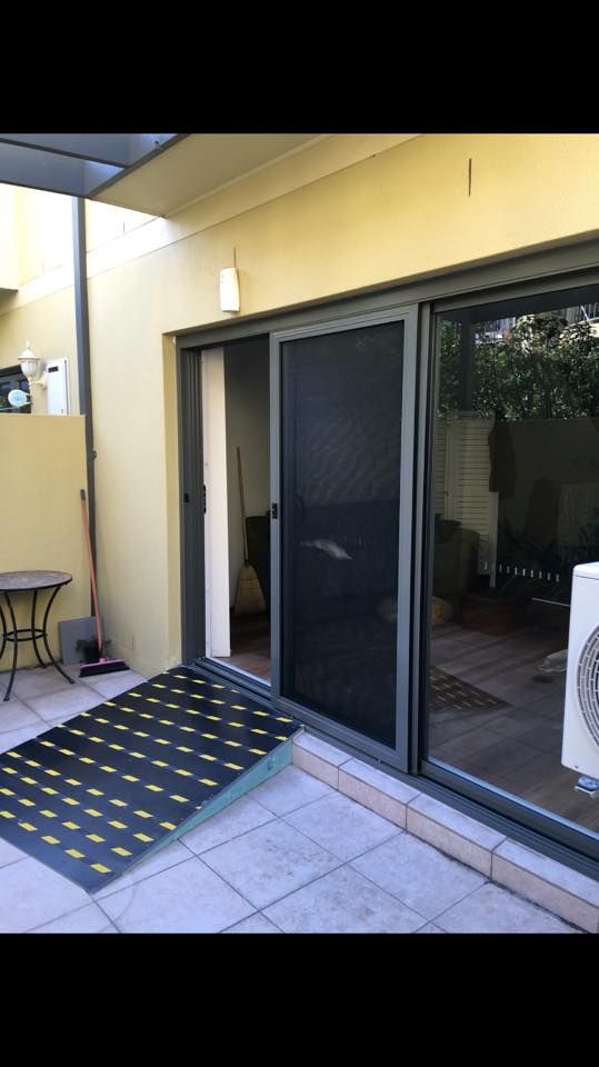 A Patio with A Sliding Glass Door and A Table — Distinctive Glass & Aluminium in Port Kembla, NSW