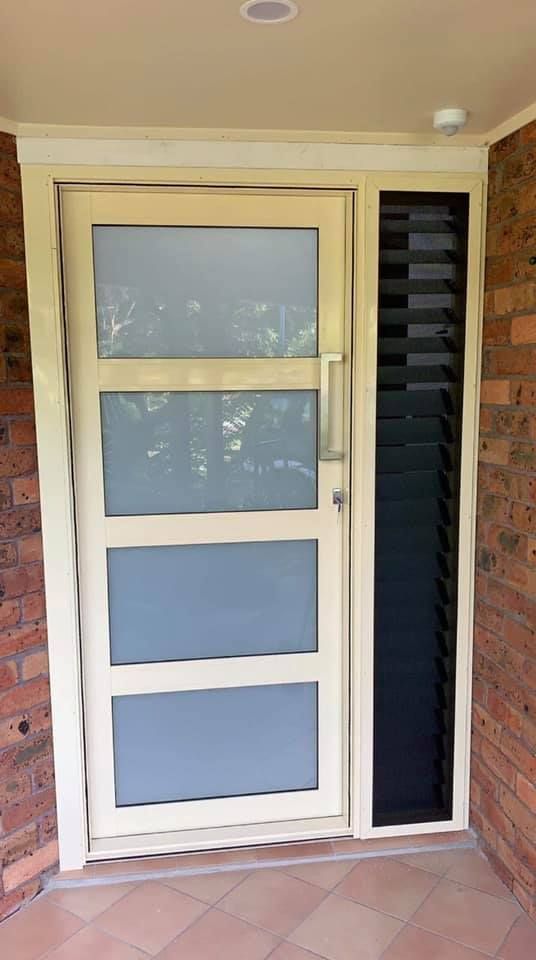 A White Door with A Black Screen on The Side of It — Distinctive Glass & Aluminium in Port Kembla, NSW