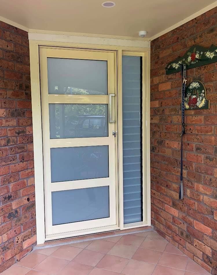 A White Door With a Brick Wall Behind It — Distinctive Glass & Aluminium In Port Kembla, NSW