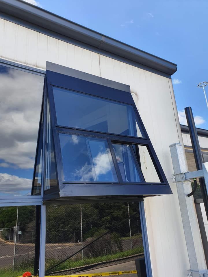 A Large Window on the Side of a Building With a Blue Sky in the Background — Distinctive Glass & Aluminium In Port Kembla, NSW