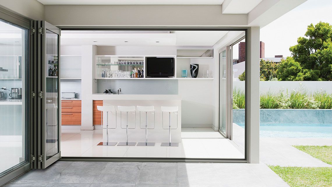 A Kitchen with Sliding Glass Doors Leading to A Pool — Distinctive Glass & Aluminium in Port Kembla, NSW