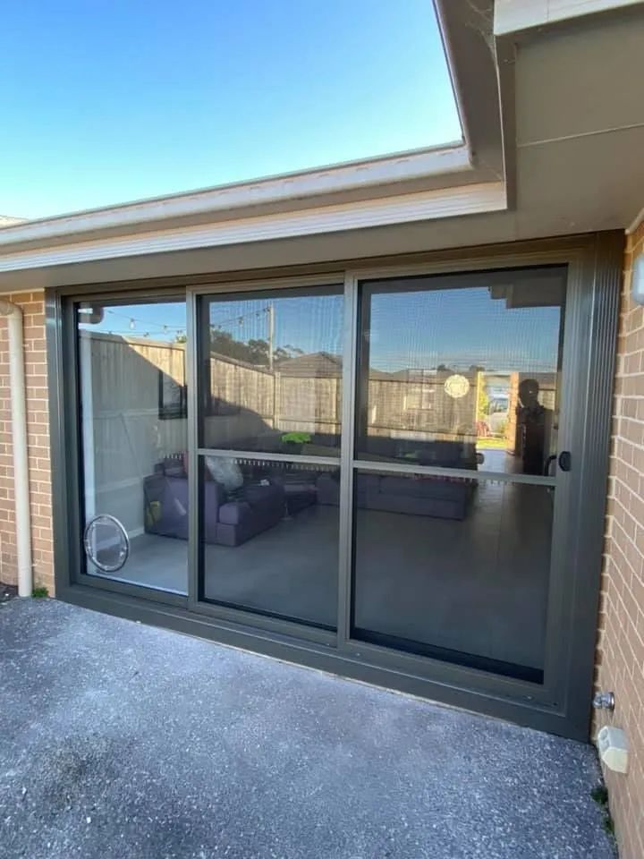 A Large Sliding Glass Door is Open to a Living Room — Distinctive Glass & Aluminium In Port Kembla, NSW