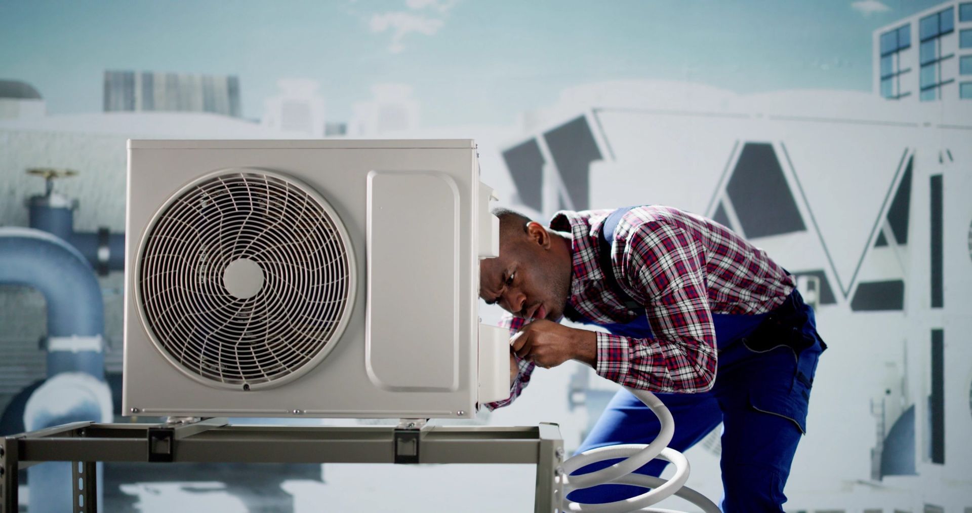 HVAC technician working on an air conditioning unit outside, using a hose.