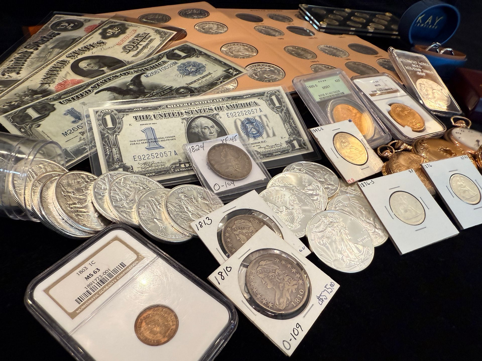 Collection of old currency, including paper bills and silver and gold coins.
