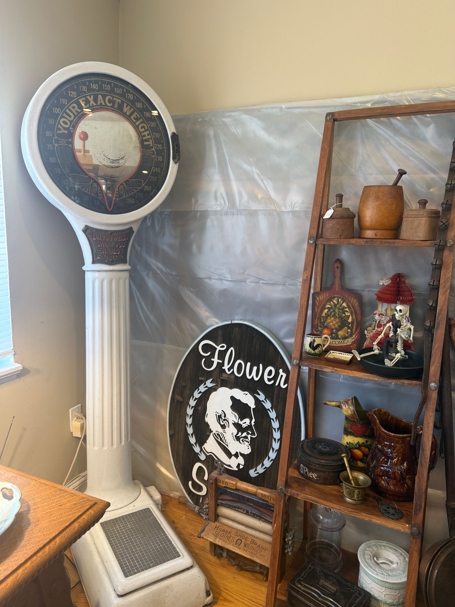 Antique scale and wooden shelf with decorative items.