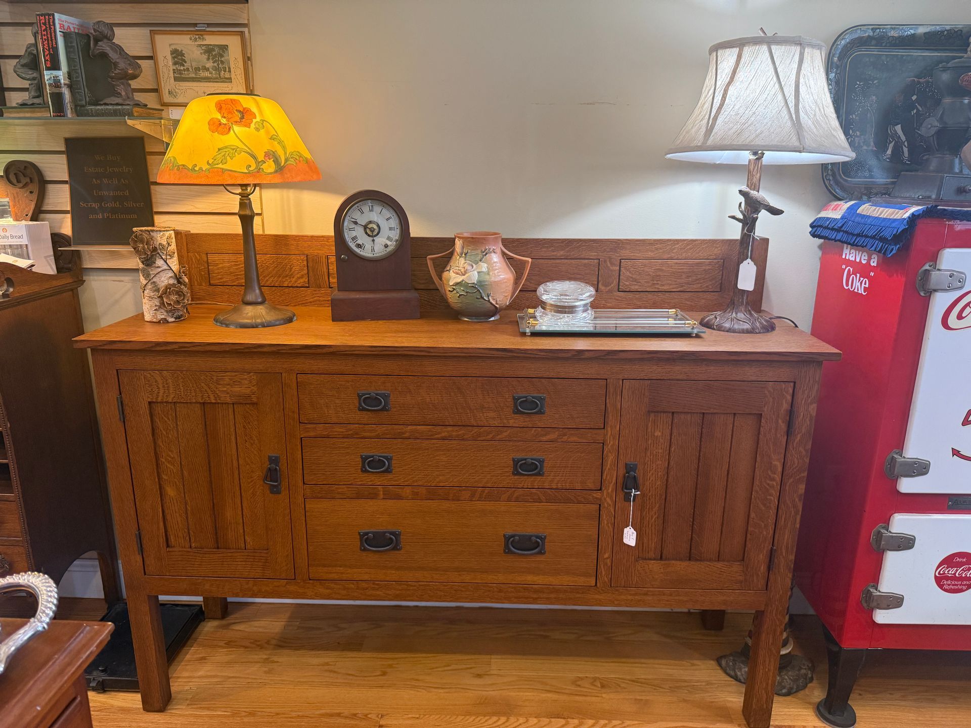 Wooden sideboard with items on top, including lamps, a clock, and decorative objects.