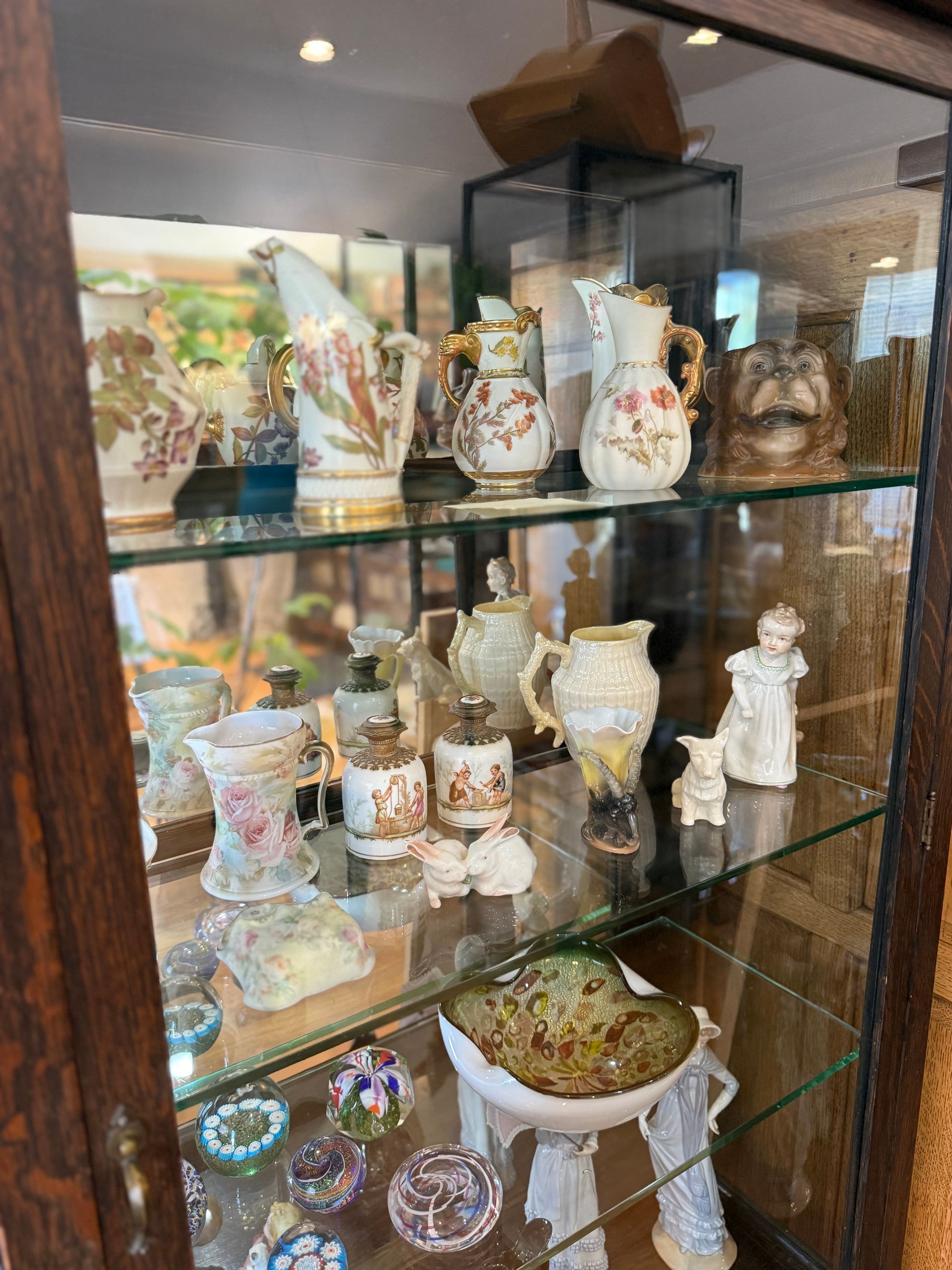 Glass cabinet displaying antique porcelain vases and figurines.