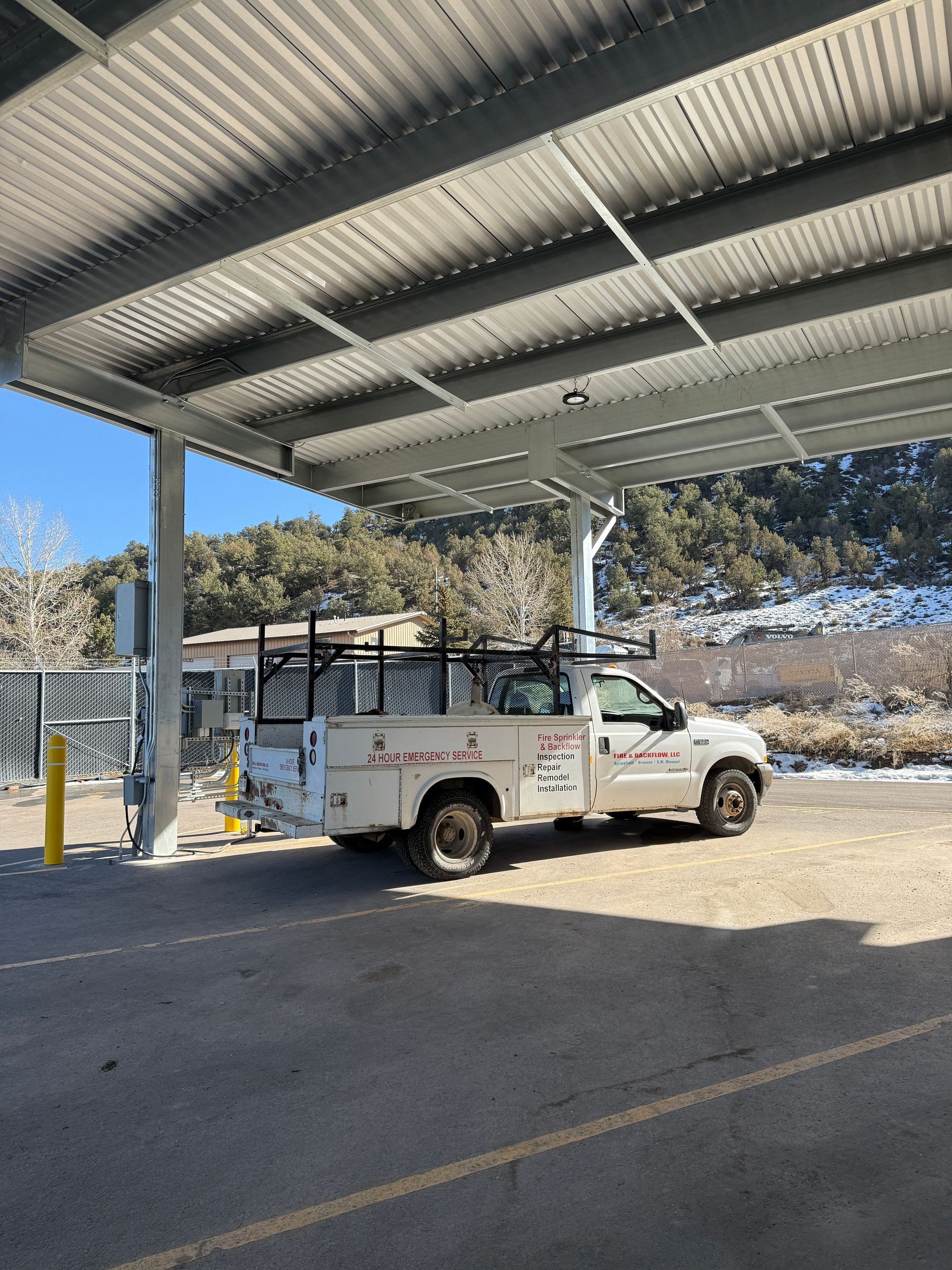 Utility truck parked in a covered, paved storage space