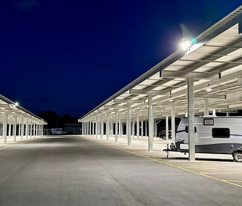 Night view of RV storage lanes with overhead lighting and covered parking