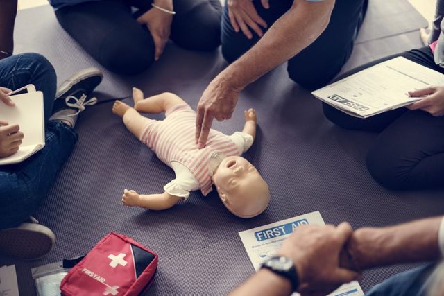 Infant CPR manikin and first aid kit during a training session