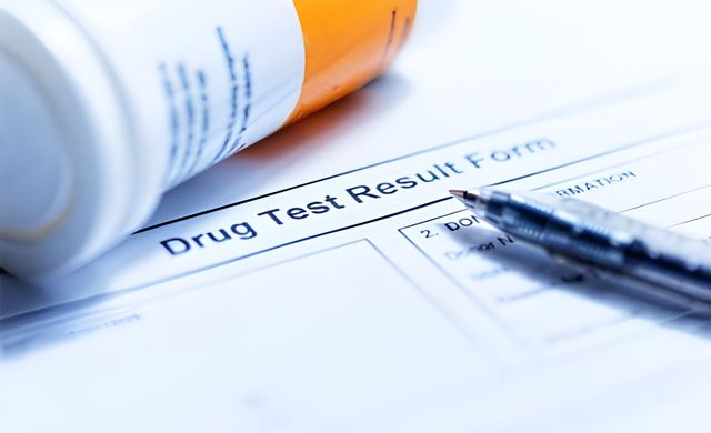 Drug test result form with a pen and pill bottle