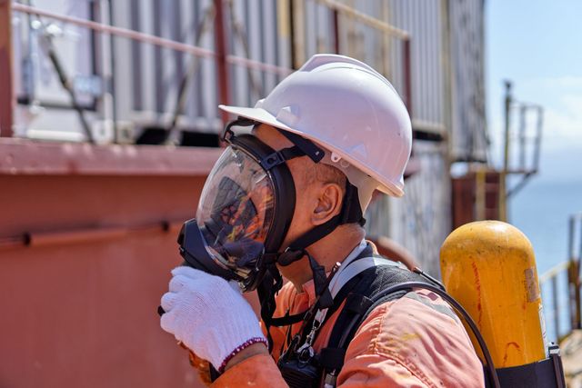 Worker wearing a full-face respirator
