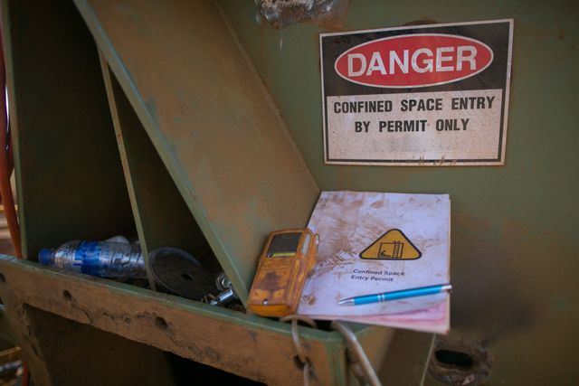 Danger sign at a tank entry reading Confined space, entry by permit only