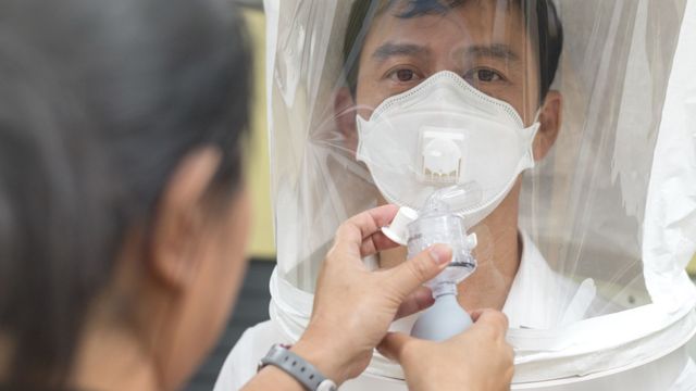 Person being fitted with a respirator mask