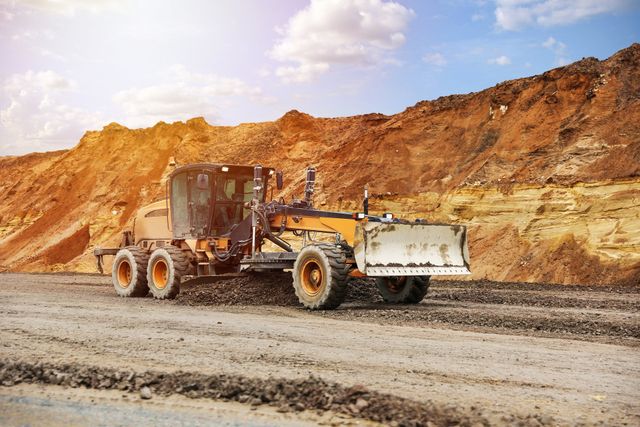 Grader working on a red-dirt earthworks site