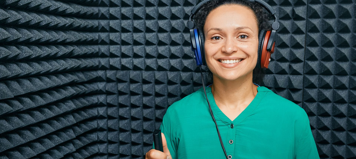 Woman wearing headphones in a sound booth during a hearing test