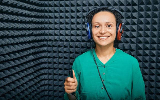 Woman wearing headphones in a sound booth during a hearing test