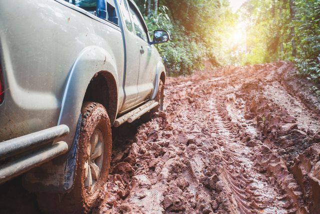Four-wheel-drive ute on a muddy bush track