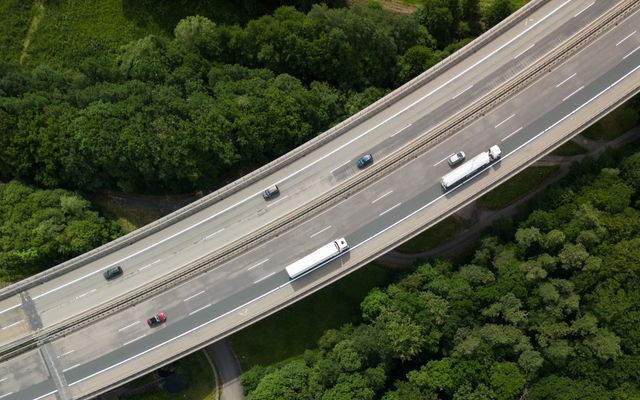 Aerial view of trucks on a highway through bushland