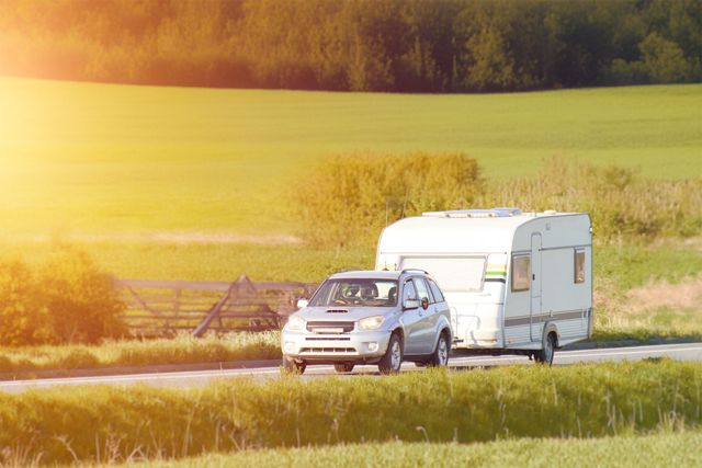 Car towing a caravan along a country road