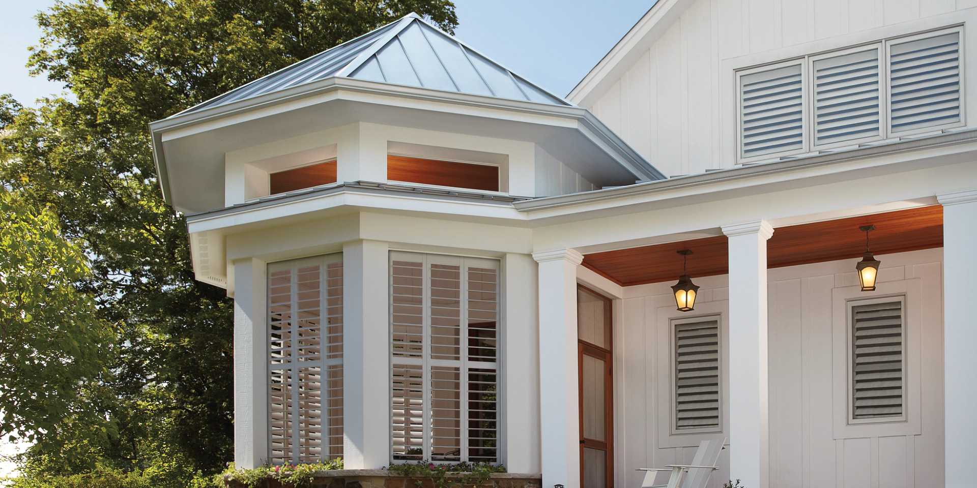 An image of a home's exterior with windows featuring gorgeous Hunter Douglas interior shutters