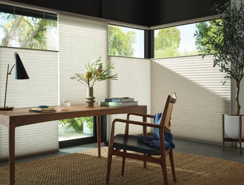 Cellular shades as home office window treatments, helping to regulate temperature and providing a ch