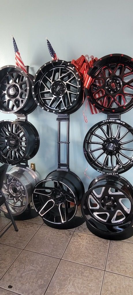 A bunch of wheels are stacked on top of each other on a rack.