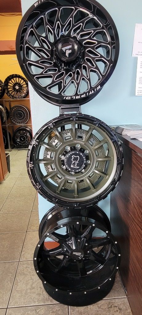 A stack of black wheels sitting on top of each other on a wall.
