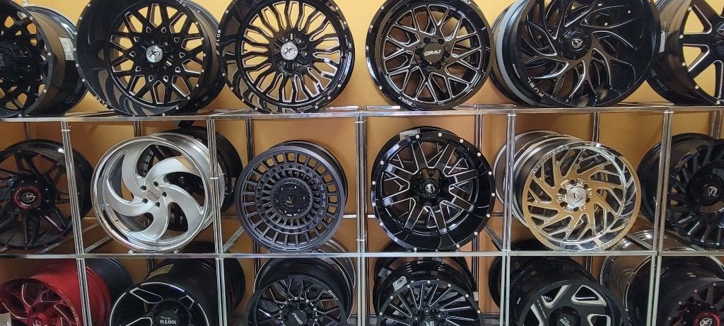 A variety of wheels are displayed on a shelf in a store.