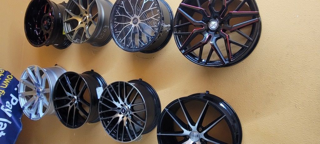 A bunch of new wheels are hanging on a wall