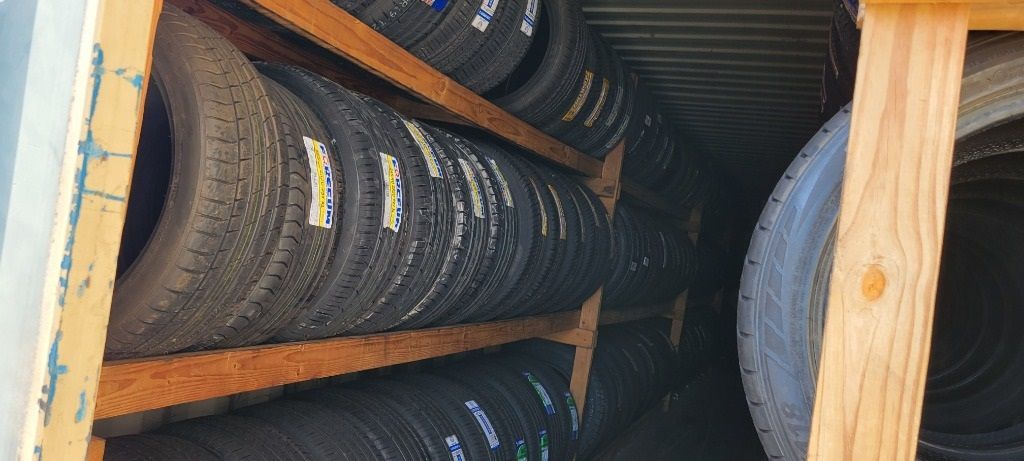 A bunch of tires are stacked on top of each other on a wooden shelf.
