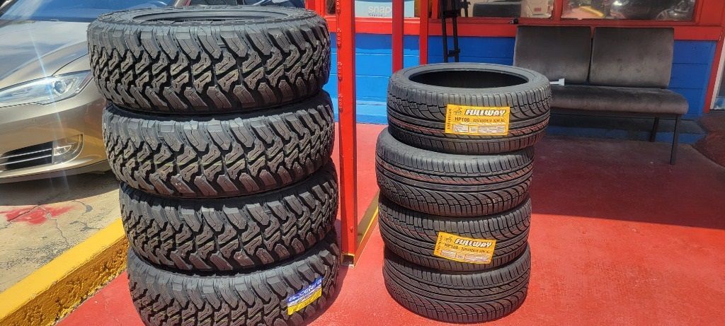 A bunch of tires are stacked on top of each other in a parking lot.