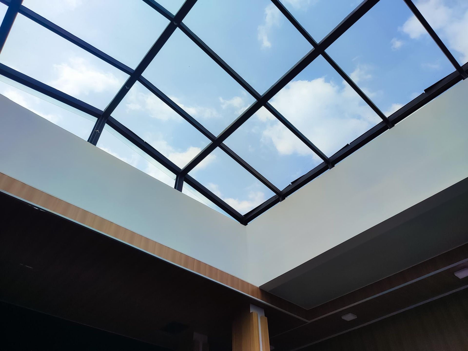 Open skylight with blue sky above a modern interior ceiling