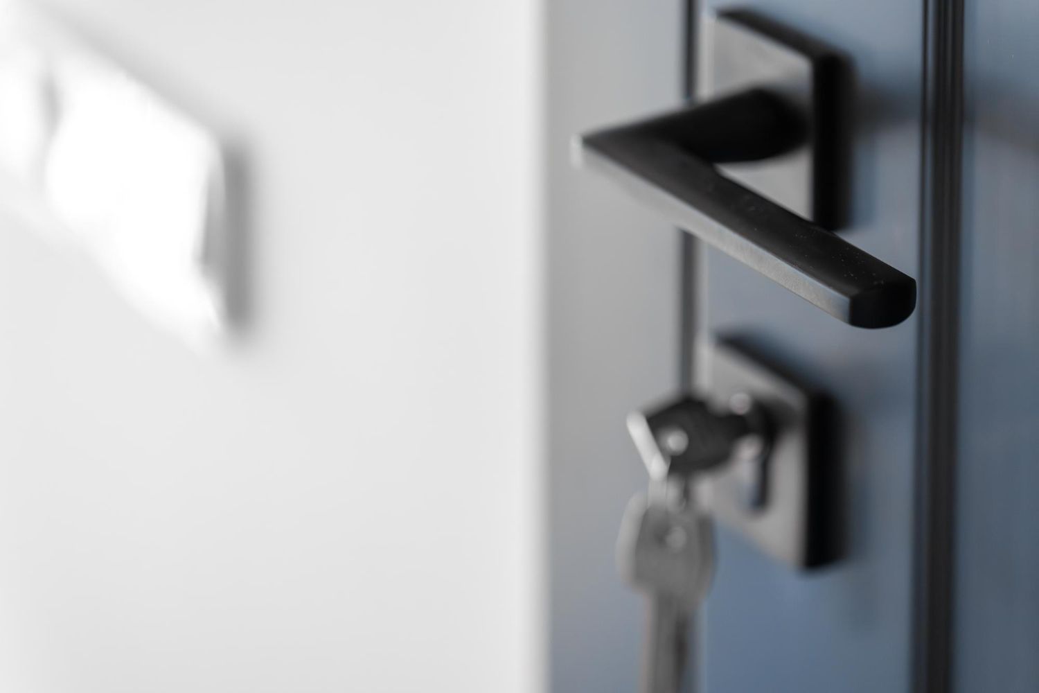 Person holding a glowing blue home security shield icon on a dark background