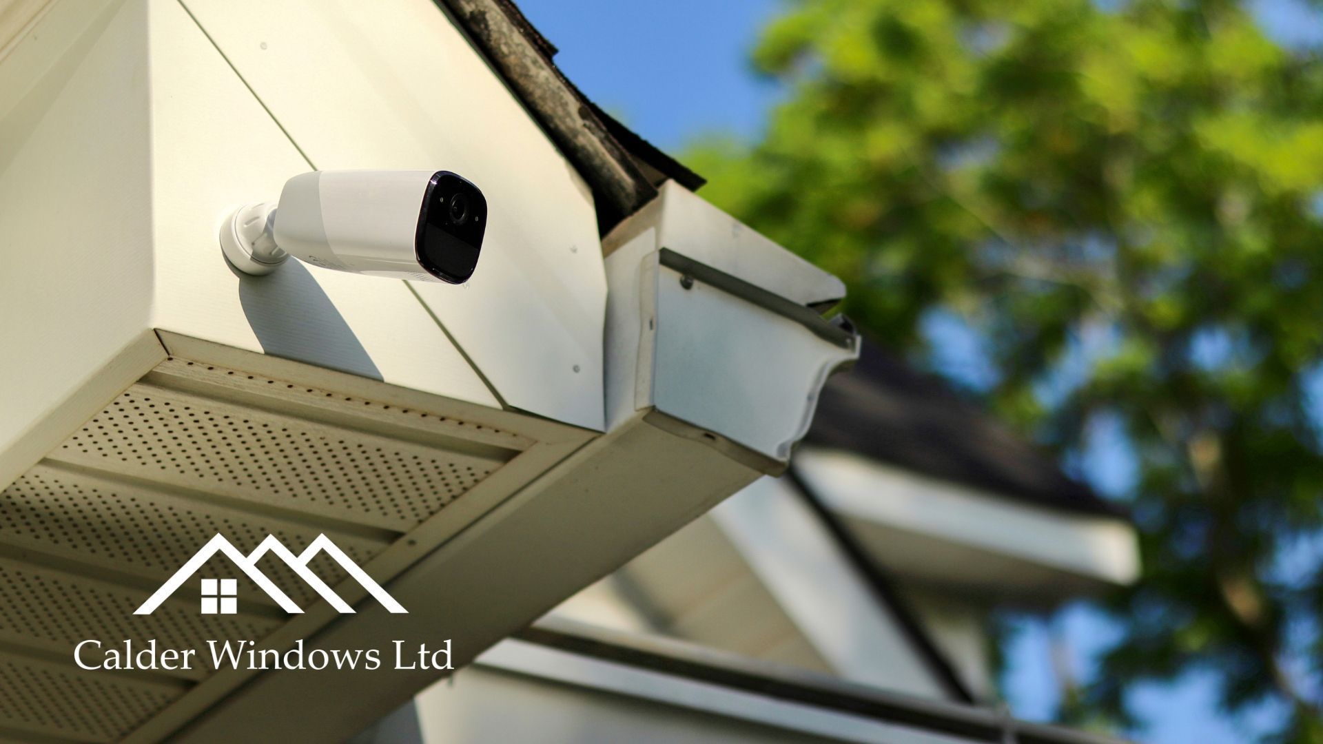 White house eaves with mounted security camera and guttering under a tiled roof