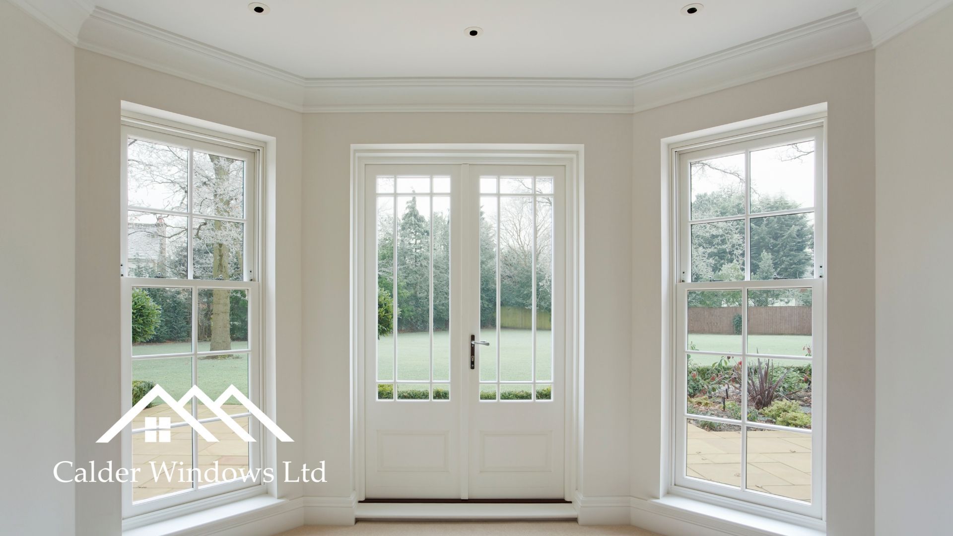 Bright bay window nook with white French doors and two matching side windows overlooking greenery