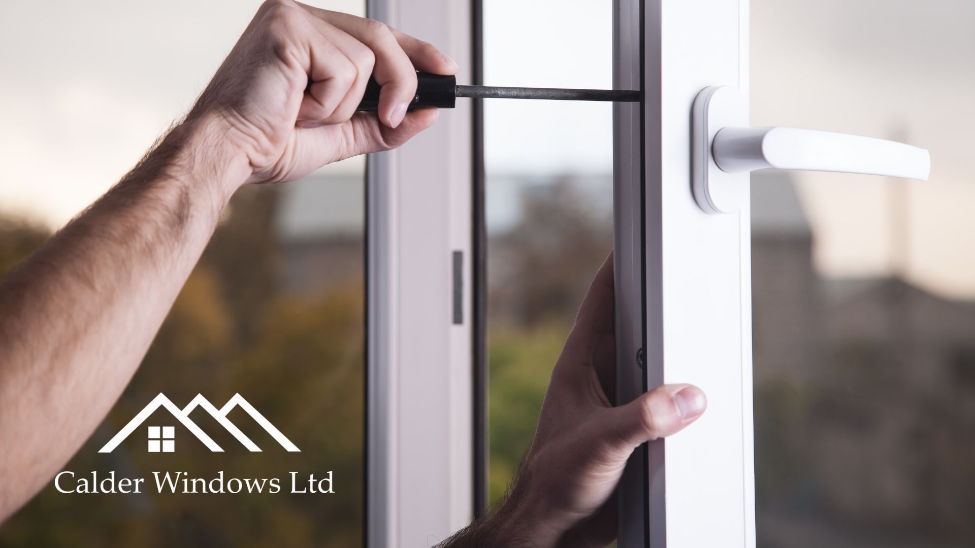 Hands installing a white door handle with a screwdriver on a glass door.