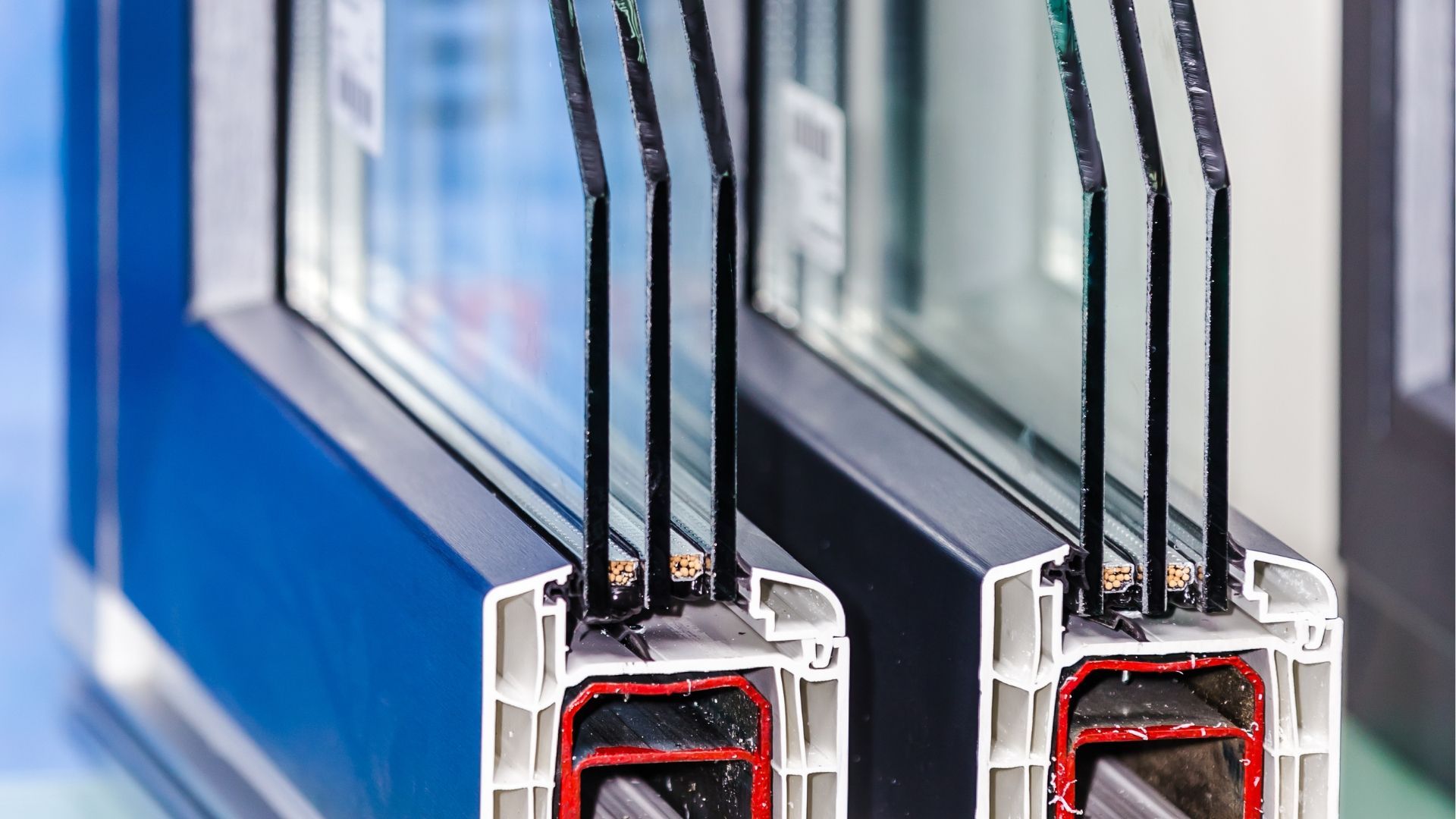 Two blue windows with black antenna-like rods and red device parts in a reflective industrial setting
