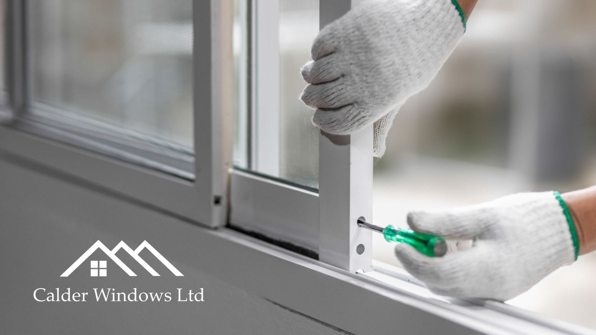 Gloved hands install a window latch on a white window frame with a green screwdriver.