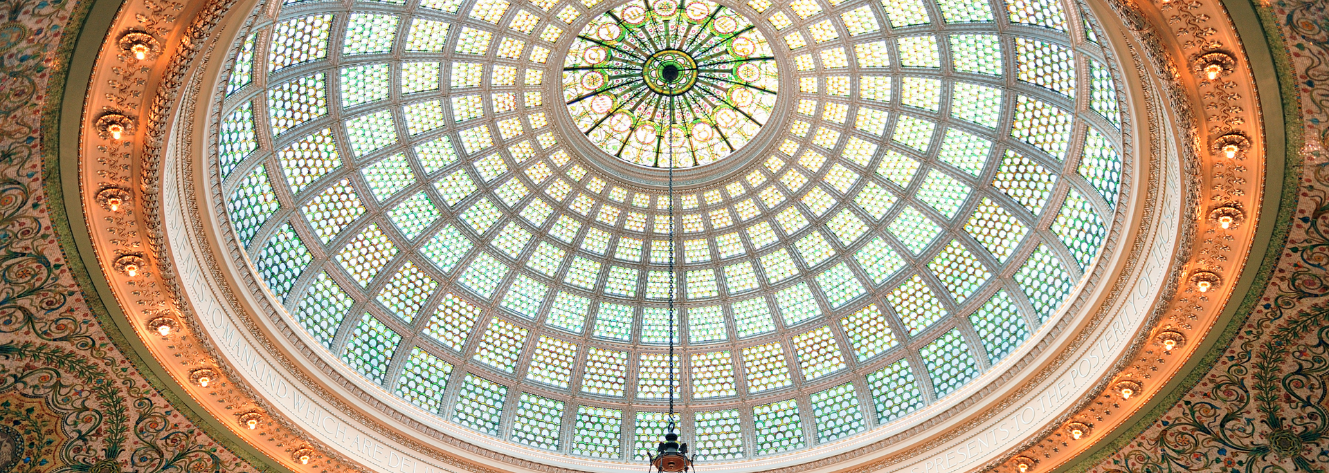 Ornate dome ceiling with a central skylight, radial glass panels, and intricate gold and turquoise patterns